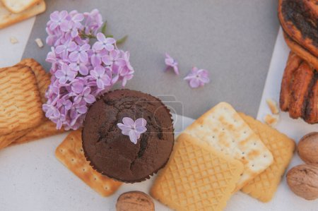 Foto de Pasteles dulces surtidos con plantilla de tarjeta vacía y flores lila, vista superior - Imagen libre de derechos