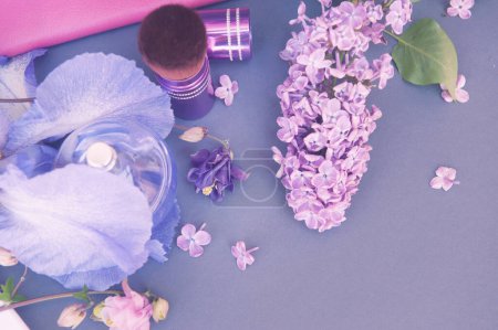 Foto de Gris mockup fondo vacío con flores violetas, círculo botella de perfume y maquillaje cepillo - Imagen libre de derechos