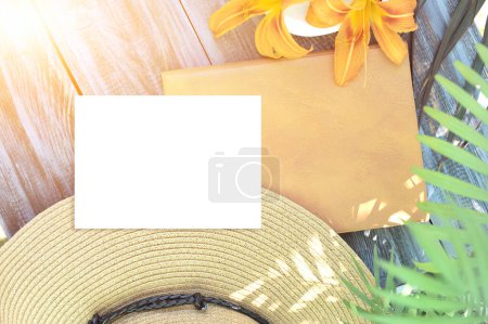 Téléchargez les photos : Modèle photo avec liste de papier blanc vide, cahier vide brun et chapeau, style d'été avec feuille de palmier - en image libre de droit