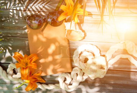 Foto de Verano estilo mar maqueta con portada de cuaderno marrón y gafas de sol, foto al aire libre con sombras de palma y flores de lirio - Imagen libre de derechos