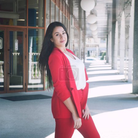 Photo for Beautiful brunette young woman outdoor portrait, businesswoman dressed in red classic trouser suit - Royalty Free Image