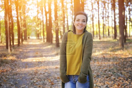 Photo for Young woman portrait, rest in a sunny park, hiking, dressed in casual wear, look at camera and smiling - Royalty Free Image
