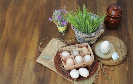 Foto de Huevos de gallina crudos ecológicos en caja de huevo natural y flores de prado, adecuados para Pascua - Imagen libre de derechos