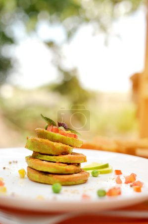 Photo for Vegetable fritters of zucchini pancakes served on a plate at outdoor cafe in sunny day - Royalty Free Image