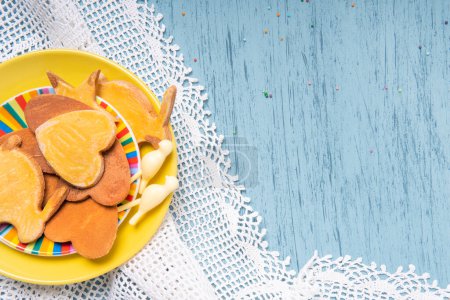 Photo for Homemade cookies on a yellow plate with knitted lace tablecloth on a kitchen table, top view - Royalty Free Image