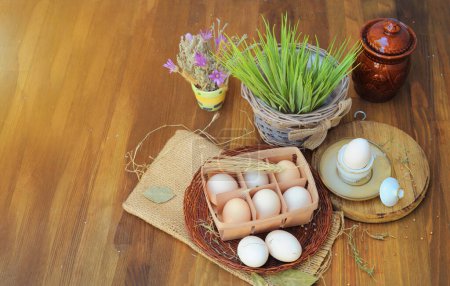 Foto de Huevos de pollo crudos ecológicos en caja de huevo natural sobre un fondo de madera - Imagen libre de derechos
