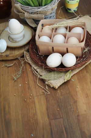 Foto de Huevos de pollo crudos orgánicos en caja de huevo natural sobre fondo de madera de estilo antiguo - Imagen libre de derechos