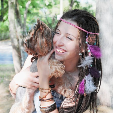 Téléchargez les photos : Happy souriant jeune femme étreindre son chien terrier yorkshire en plein air dans le parc - en image libre de droit