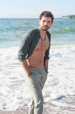 Foto de Joven hombre en topless retrato al aire libre senderismo cerca del mar en la gran ciudad - Imagen libre de derechos