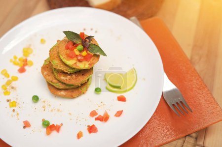 Téléchargez les photos : Beignets de courgettes de légumes servis dans une assiette dans un café extérieur - en image libre de droit