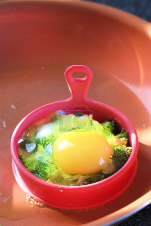 Photo for Egg roasted with broccoli in silicone mold on a frying pan, homemade food - Royalty Free Image