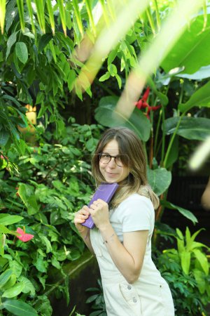 Téléchargez les photos : Jeune botaniste au travail dans un jardin botanique - en image libre de droit