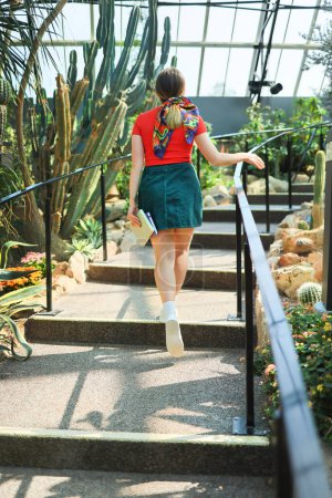 Téléchargez les photos : Happy walking femme en plein air dans un jardin tropique, vue de dos - en image libre de droit