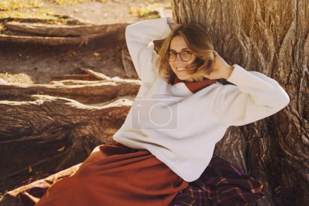 Photo for Beautiful young woman portrait in autumn park dressed in long brown skirt and white sweater - Royalty Free Image
