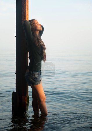 Photo for Depressed thoughtful woman portrait on a sea beach mooring - Royalty Free Image