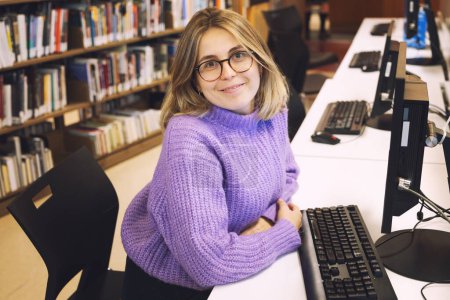 Téléchargez les photos : Jeune belle femme bibliothécaire travaillant dans une bibliothèque municipale - en image libre de droit