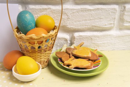 Foto de Cesta de Pascua con huevos de colores y galletas de vacaciones - Imagen libre de derechos