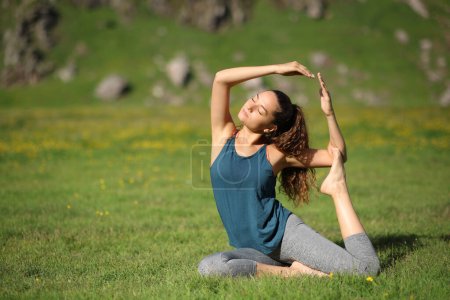 Foto de Yogui haciendo ejercicio de yoga sobre la hierba de un campo en la naturaleza - Imagen libre de derechos