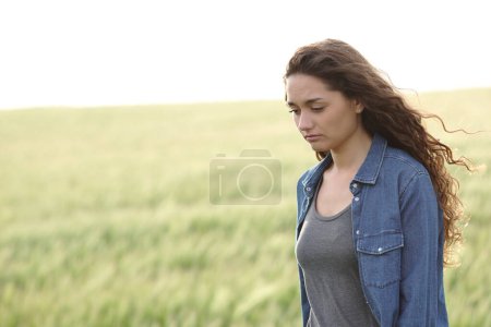 Traurige Frau läuft allein in einem Weizenfeld