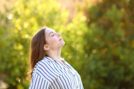 Foto de Perfil de una mujer que respira aire fresco en un parque - Imagen libre de derechos