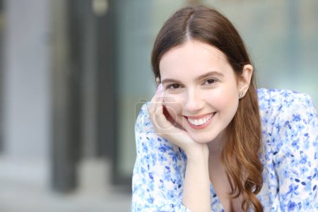 Téléchargez les photos : Portrait d'une femme heureuse souriant à la caméra avec des dents blanches parfaites dans la rue - en image libre de droit