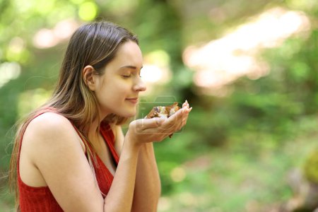 Photo for Happy woman smelling death leafs in a forest - Royalty Free Image