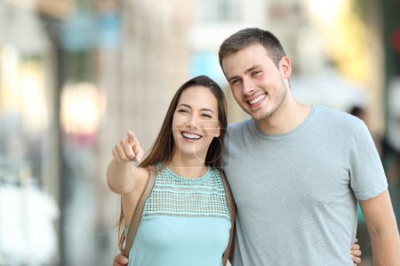 Vorderseite Porträt eines glücklichen Paares, das etwas auf die Straße zeigt