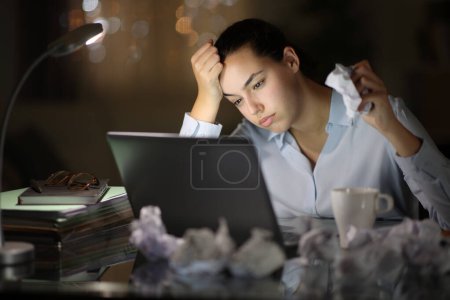 Frustrated entrepreneur crumpling papers working in the night at home