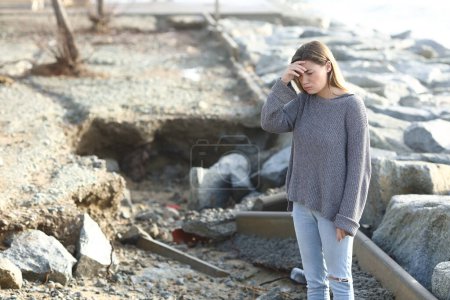 Trauriges besorgtes Mädchen blickt nach Unwetter auf die Katastrophe auf der Straße
