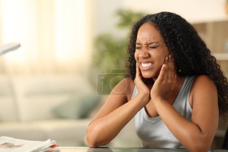 Schwarze Frau leidet tmj beschwert sich sitzend zu Hause