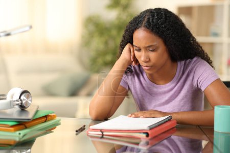 Black student studying memorizing notes sitting at home