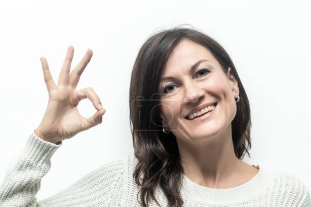 Photo for Positive Communication: Woman Giving OK Sign on White Background - Royalty Free Image