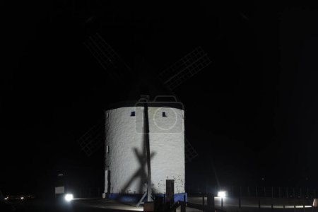 Foto de Molinos de viento iluminados de Consuegra lanzan un hechizo en la oscuridad española - Imagen libre de derechos