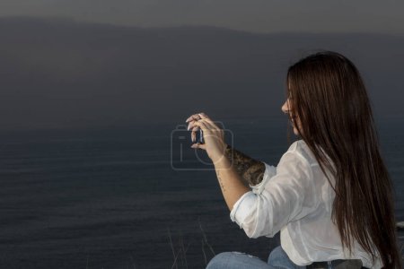 Téléchargez les photos : La femme s'imprègne de créativité, en brisant des souvenirs sur la côte - en image libre de droit