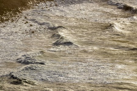 Foto de Capturando la tranquila belleza de las olas al atardecer en la costa - Imagen libre de derechos