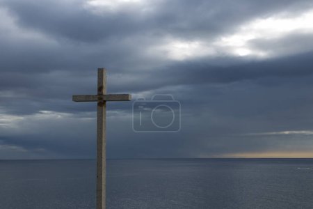 Téléchargez les photos : Réconfort spirituel au bord de la mer : la croix chrétienne se tient au milieu de la beauté côtière des Asturies - en image libre de droit
