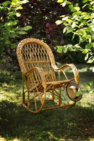 Téléchargez les photos : Chaise confortable en osier dans le jardin d'été. Endroit hygge confortable pour - en image libre de droit