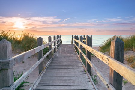 Téléchargez les photos : Coucher de soleil le long de la plage avec vue sur les dunes à un belvédère avec un coup de soleil - en image libre de droit