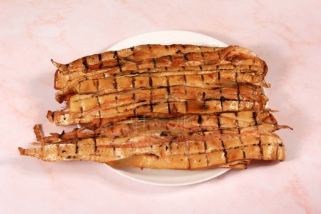 Téléchargez les photos : Tranches de ventre de saumon fumé sur assiette blanche, fond rose. collation de poisson - en image libre de droit