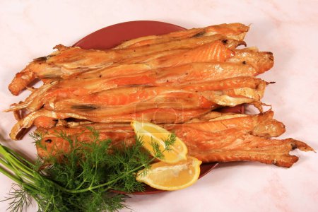 Photo for Slices of smoked salmon belly on red plate, pink background. fish snack - Royalty Free Image