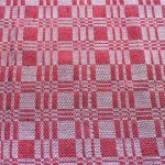    A beautiful closeup of a hand knitted warm and soft wool pattern.Texture of natural red fabric with pattern. Interior, background, structure.                            
