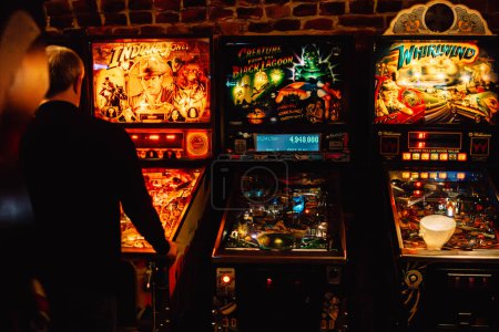 Photo for Krakow, Poland - November 17, 2023: Man playing in a game hall with pinball machines - Royalty Free Image
