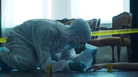 Photo for Detective Collecting Evidence in a Crime Scene. Forensic Specialists Making Expertise at Home of a Dead Person. The Concept of Homicide Investigation by Professional Police Officer. - Royalty Free Image