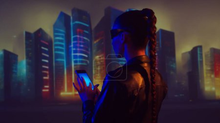 Téléchargez les photos : Portrait de cyberpunk girl. Belle jeune femme sur le fond des grattoirs de la ville. Concept futuriste. - en image libre de droit