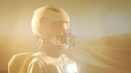 Foto de Una astronauta en traje espacial explora otro planeta. Joven cosmonauta en traje espacial en Marte. Concepto de viaje galáctico y ciencia. - Imagen libre de derechos