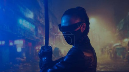 Photo for Cyberpunk ninja girl in a mask and with a katana. Beautiful female samurai woman on the background of Asian city downtown street. - Royalty Free Image