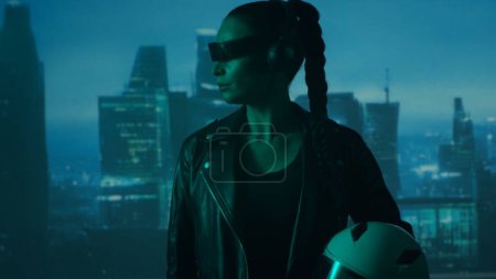 Retrato de chica cyberpunk con un smartphone en gafas y auriculares. Hermosa joven en el fondo de rascacielos de la ciudad. Concepto futurista.