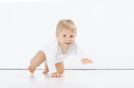 Foto de Pequeño, feliz y sonriente bebé lindo en el estudio. Retrato de un bebé de un año. Fondo blanco aislado. El concepto de felicidad. - Imagen libre de derechos