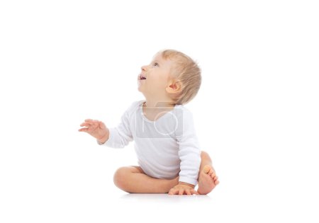 Téléchargez les photos : Petit, heureux et souriant bébé mignon dans le studio. Portrait d'un bébé d'un an. Fond blanc isolé. Le concept de bonheur. - en image libre de droit