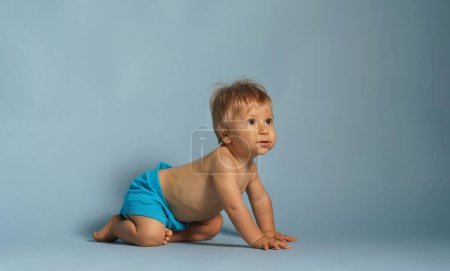 Photo for Little, happy and smiling cute baby in the studio. Portrait of a one year old baby. Blue background. The concept of happiness. - Royalty Free Image